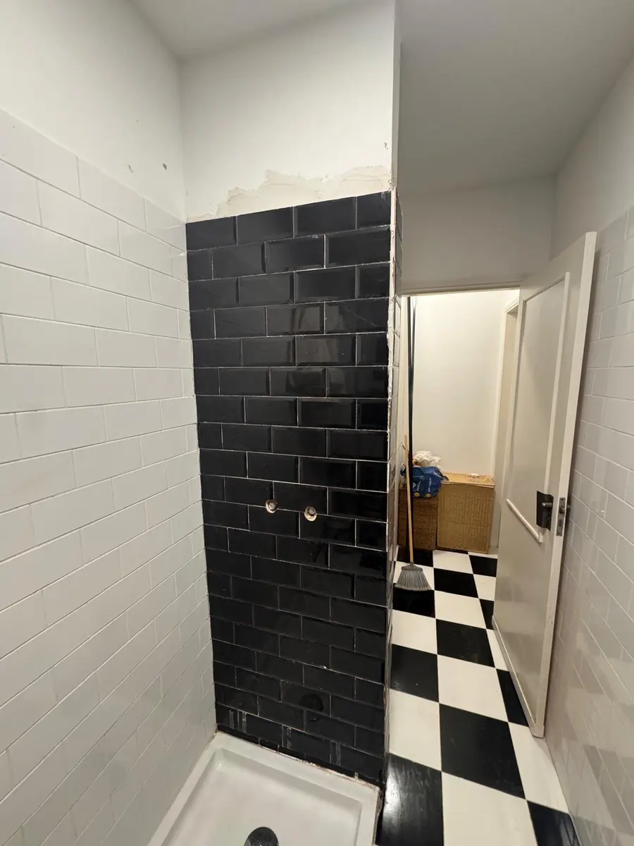 Casa de banho remodelada com azulejo preto tipo metro
